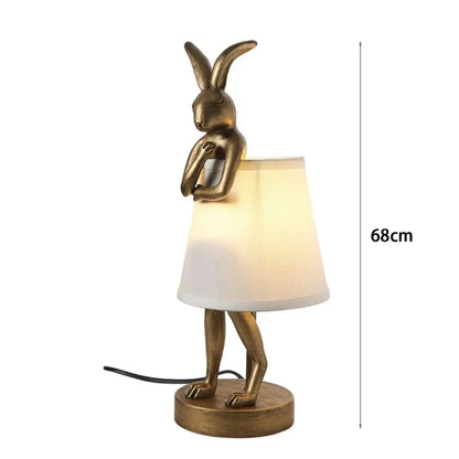 Golden bathing rabbit resin table lamp with white fabric shade for bedroom decor by DecorBites