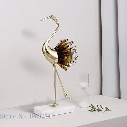 Golden bird agate crane statue with translucent amber glass feathers on white marble base for home decor