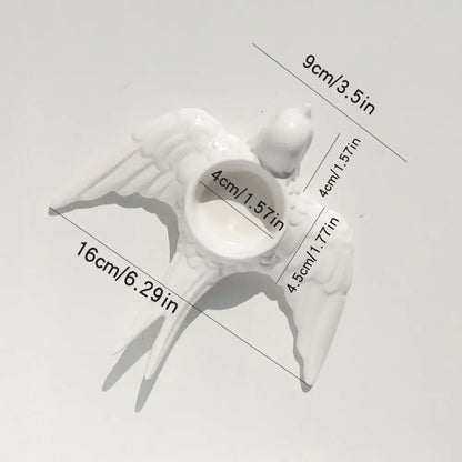 White ceramic bird-shaped candle holder tray with detailed wings and central circular opening for wedding decor