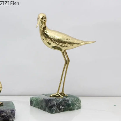 Golden brass bird desk ornament standing on a green marble base for living room decor statues