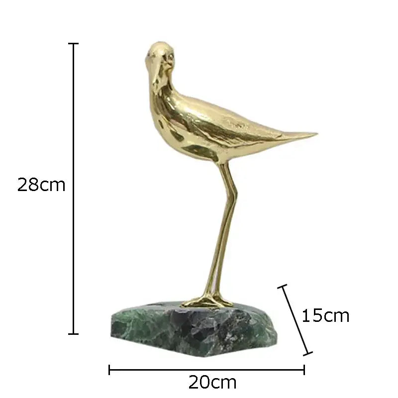 Golden brass bird desk ornament standing on a green marble base for elegant living room decor