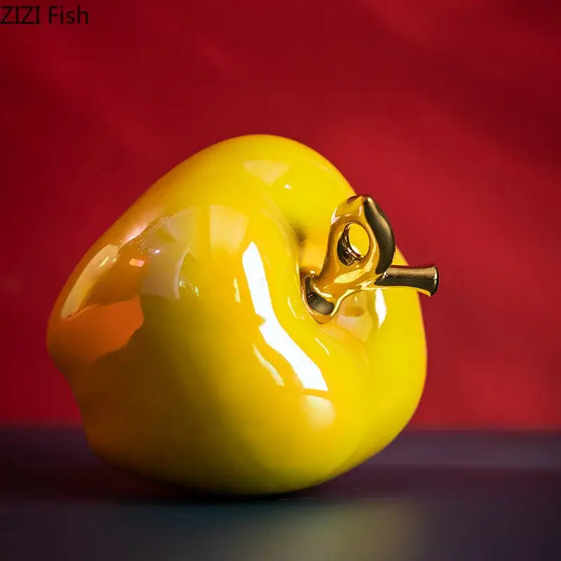 Glossy yellow ceramic apple sculpture with gold-toned stem for living room table decor