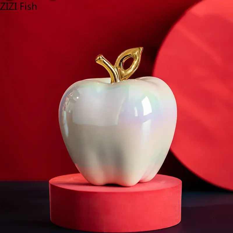 Iridescent white ceramic apple sculpture with a gold leaf and stem for living room table decor