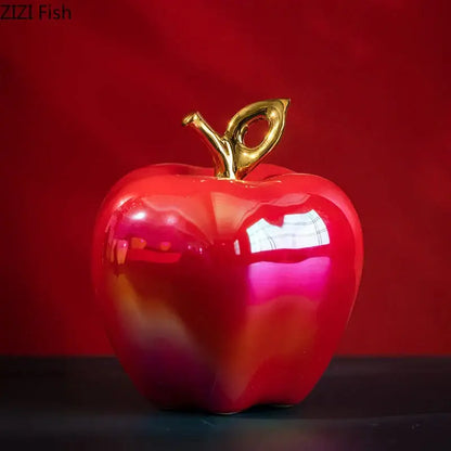 Shiny red ceramic apple sculpture with a gold-colored stem for living room table decor