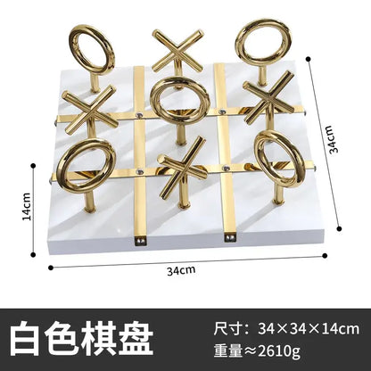Golden chessboard metal handicraft tic-tac-toe set with gold-colored circular and cross pieces on white base decorbites decor