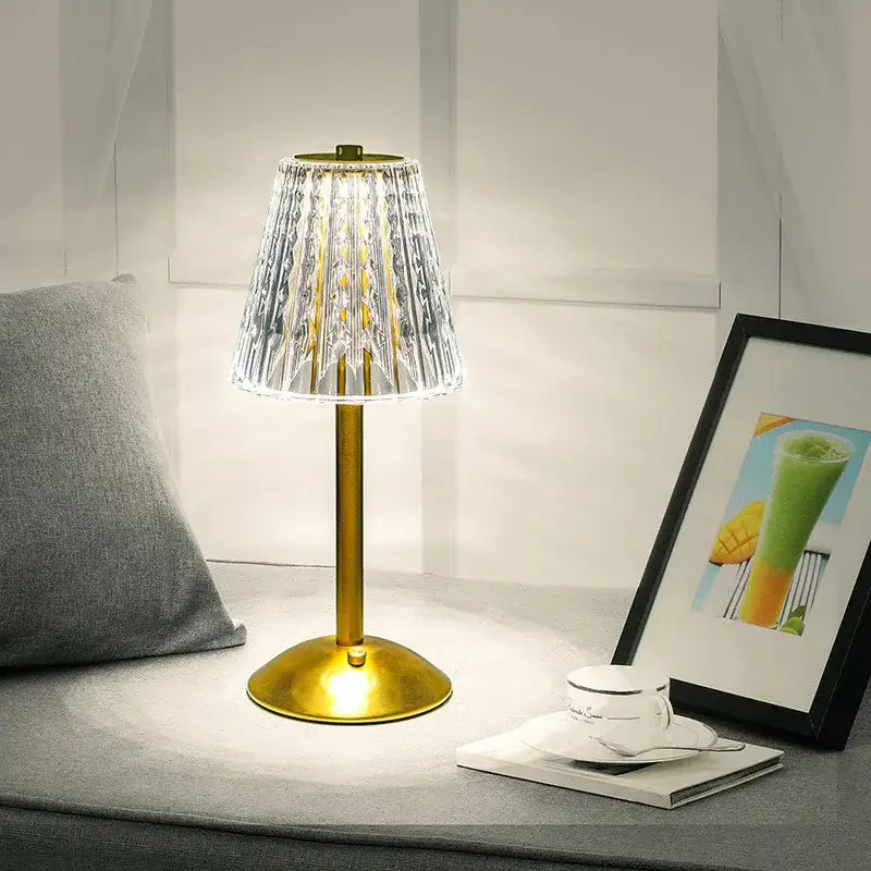 A golden crystal diamond touch sensor table lamp with a faceted crystal shade for bedroom use