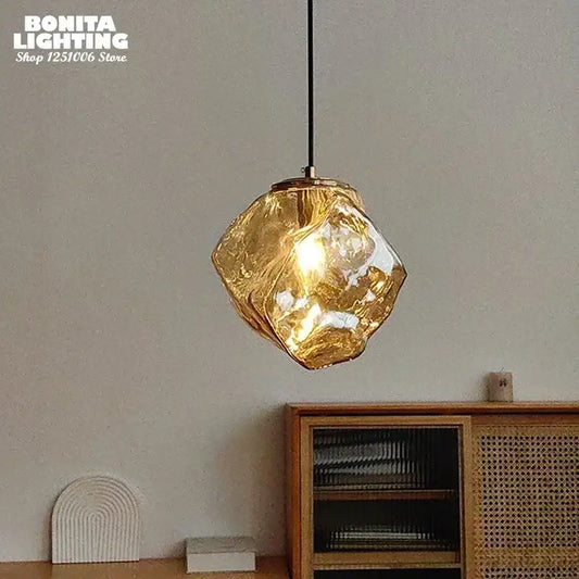 Golden faceted glass pendant light emitting a warm glow ideal for layered lighting in dining rooms