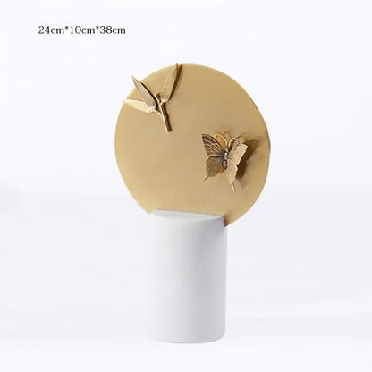 Gold-toned circular decorative figurine set with butterfly and leaf motif on white base for home decor by decorbites golden geometric