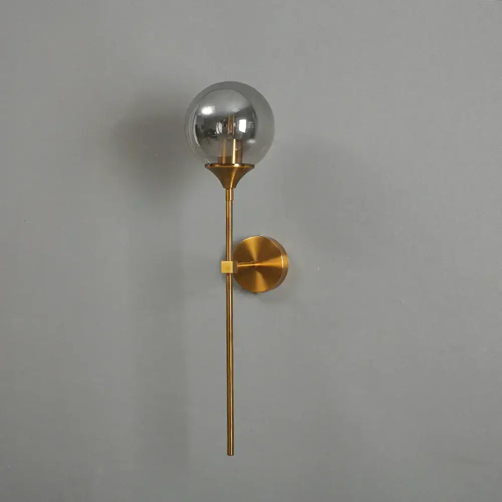 A sleek brass decorbites golden glass ball led wall light with clear glass globe and minimalist design for bedroom decor