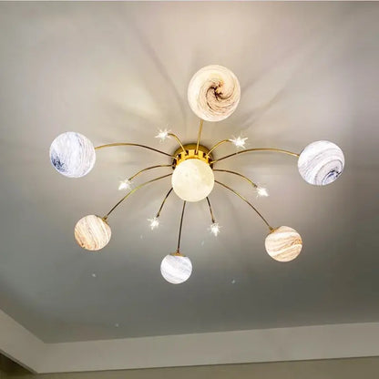 Gold-toned ceiling fixture with six glass ball planet lights featuring marbled white, beige, and brown patterns for kids room decorbites glass ball