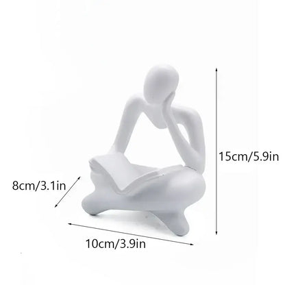White resin figurine of a seated abstract thinker holding an open book decorbites abstract thinker resin office decor