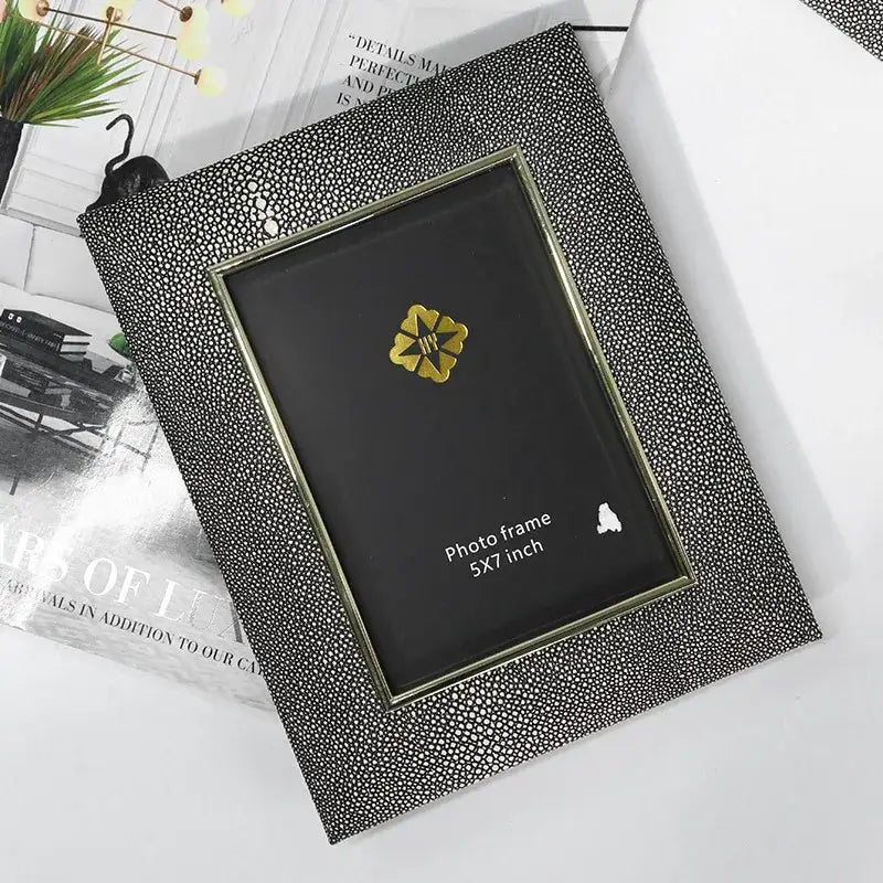 Black shagreen-textured photo frame with gold-toned inner border and flower emblem for decorbites gradient shell ceramic decor