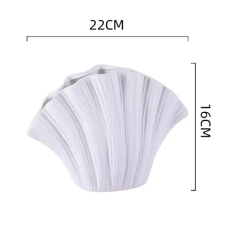 White ceramic vase shaped like a scallop shell with vertical ridges for decorbites gradient shell living room decor