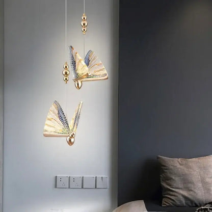 Gold-toned decorbites crystal butterfly pendant lamp with iridescent wings and spherical accents for bedroom lighting