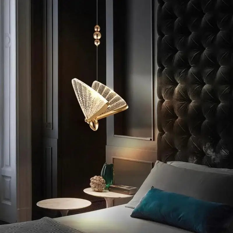 Golden iridescent crystal butterfly pendant lamp with fan-shaped intricate mesh design and sleek metallic finish for bedroom lighting