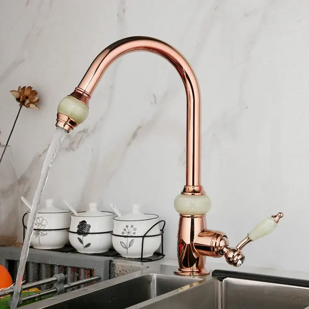 Rose gold kitchen faucet with golden jade ceramic accents diamond handle and a curved swivel pull spout
