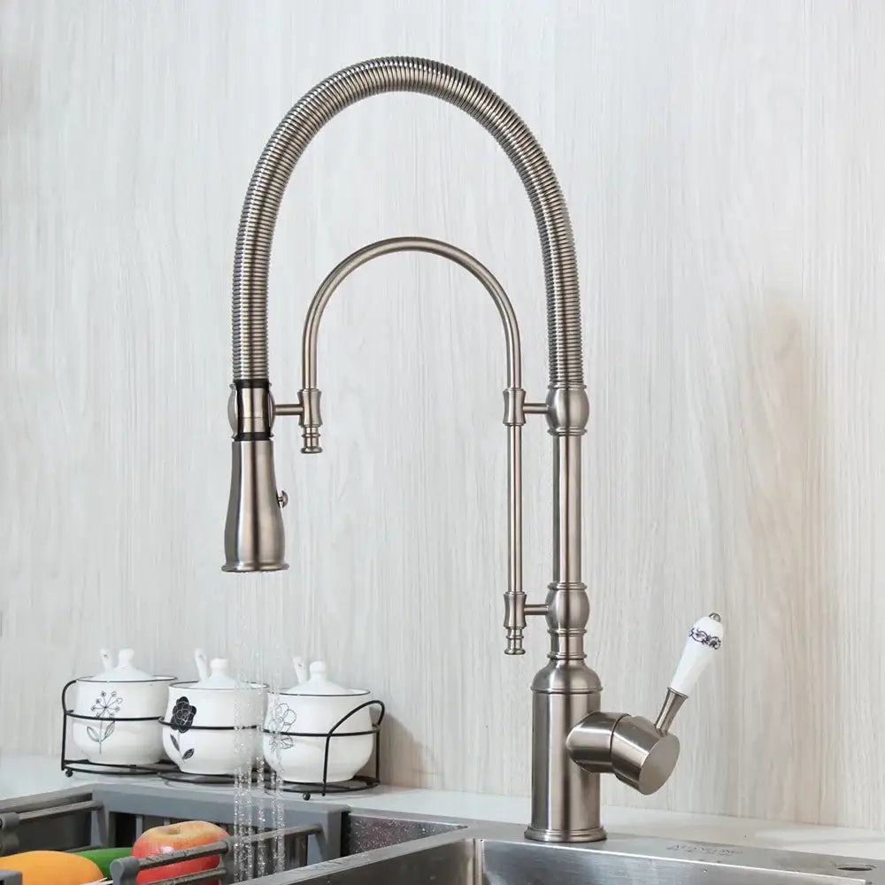 Golden kitchen faucet with stainless steel flexible gooseneck spout and white ceramic handle with black floral decorbites design
