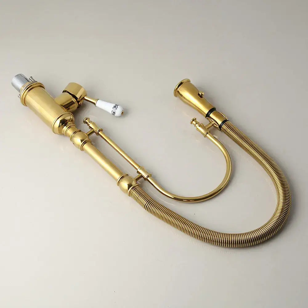 Golden kitchen faucet with white ceramic handle featuring black detailing and flexible brass corrugated hose by decorbites