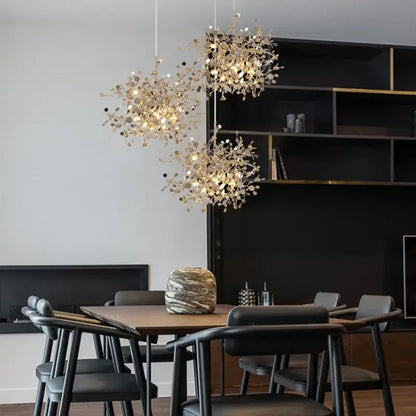 Three elegant gold-toned leaf pendant lights with intricate branch designs hang above a dining table decorbites g9 leaf