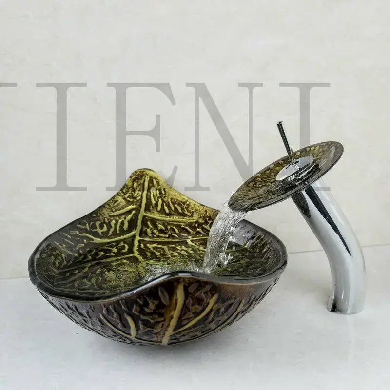 A sleek brown glass decorbites golden leaf vessel sink set featuring intricate golden veining with a polished chrome faucet