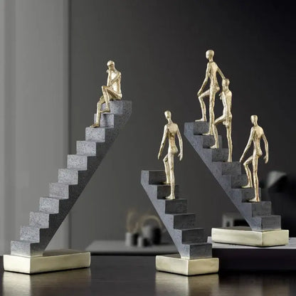 Golden man abstract resin sculpture with golden figurines on concrete staircases and metallic bases for living room decor