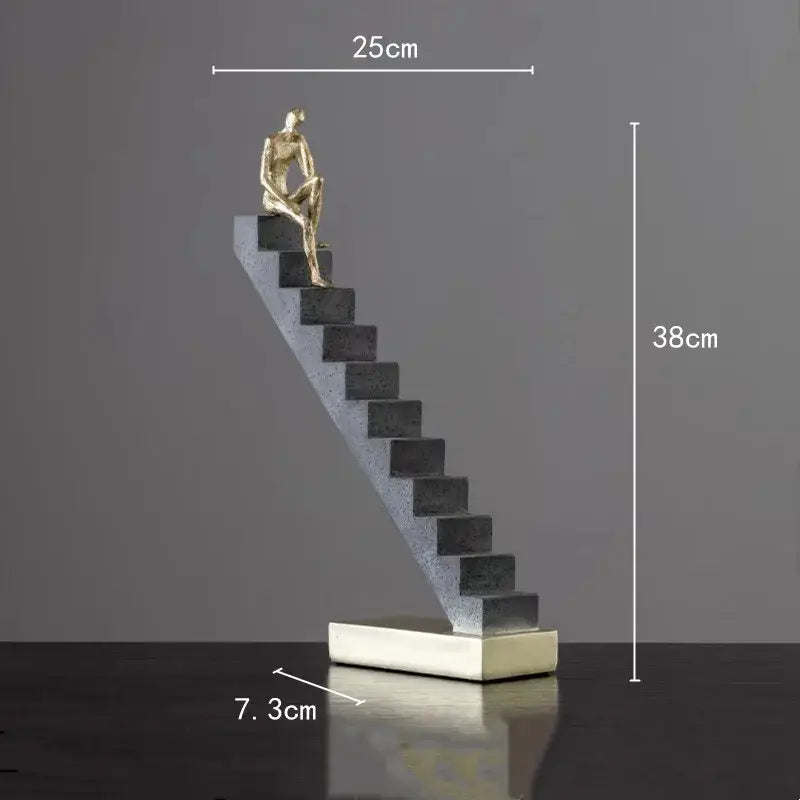 Golden man abstract resin sculpture of a seated figure on dark gray steps with white base for living room decorbites decor