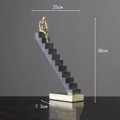Golden man abstract resin sculpture of a seated figure on dark gray steps with white base for living room decorbites decor