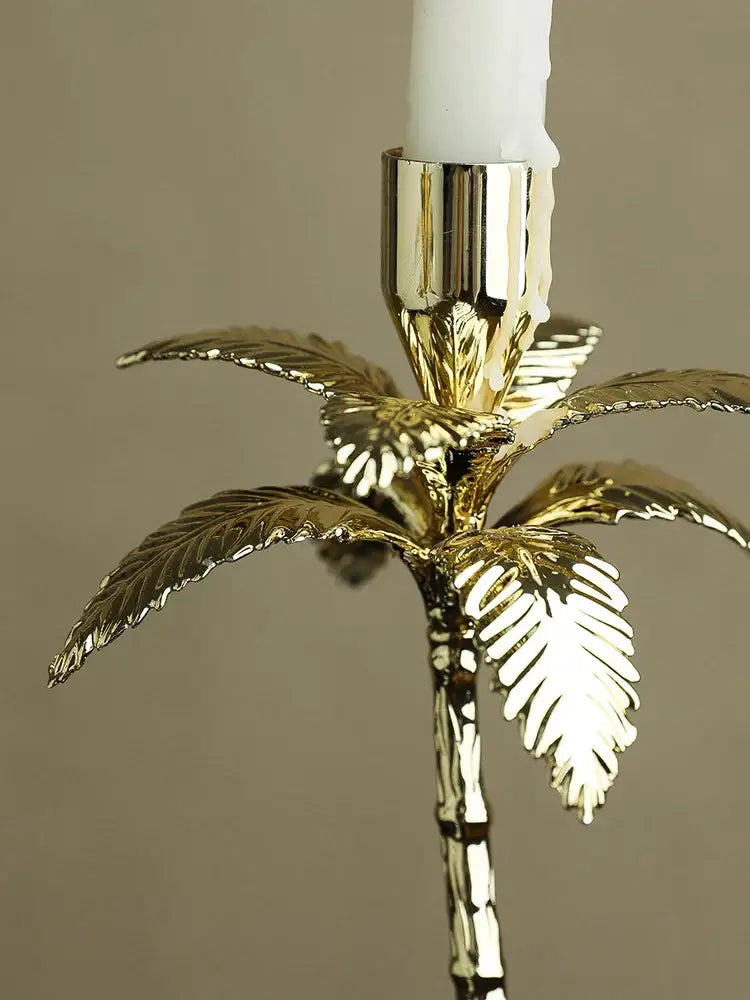 Golden metal candlestick palm tree with white wax candle and marble base for elegant home decor by decorbites