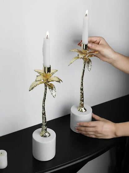 Golden metal candlestick palm tree candle holders with white candles on cylindrical marble bases for home decorbites decor