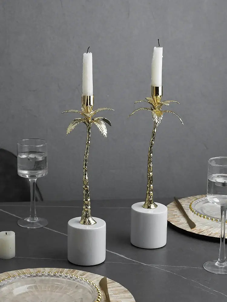 Golden metal candlestick palm tree candle holders with white candles on marble bases for home decorbites decorbites golden metal