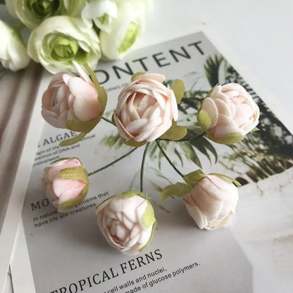 A delicate cluster of pink fabric roses with green ribbon accents and golden metallic berry stamen green plant decorbites green plant decor