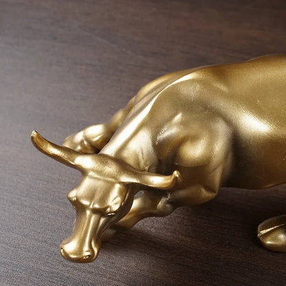 Golden metallic bull figurine with detailed musculature and prominent horns for living room feng shui decor by decorbites