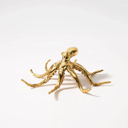 Golden octopus metal sculpture with detailed textured arms and smooth head for living room decor by decorbites