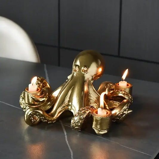 Golden octopus sculpture candle holder with three lit candles in ornate textured cups for dining room decorbites decor