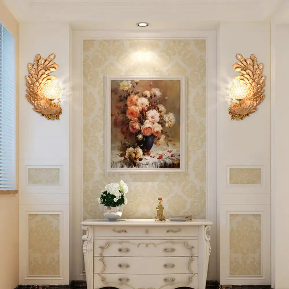 Golden peacock wall light with crystal shade featuring warm glowing yellow and green tones for living room decor