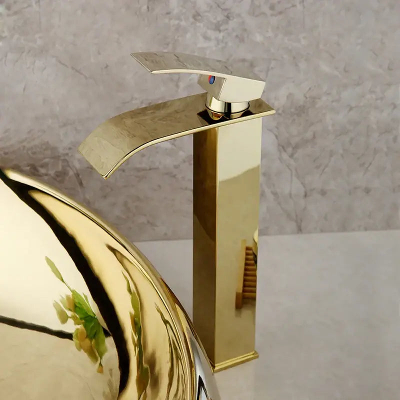 Gold-finished modern waterfall faucet with sleek rectangular spout in decorbites golden plated ceramic basin sink set