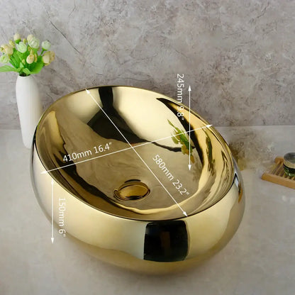 Shiny gold ceramic vessel sink with smooth reflective surface and rounded oval shape in decorbites golden plated basin set
