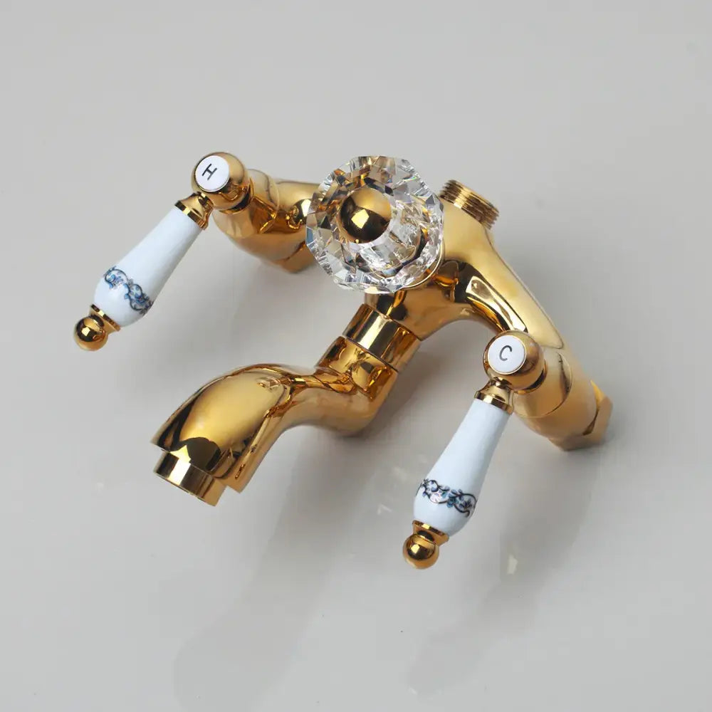 Golden polished shower head with gold finished faucet featuring crystal knob and white ceramic handles with blue floral decorbites golden polished
