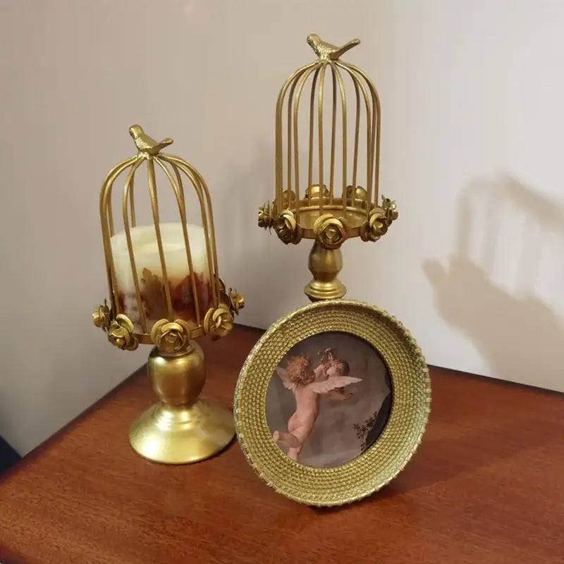 Golden rose birdcage style ornament candle holder with ornate detailing and small bird figurine for dining room decor