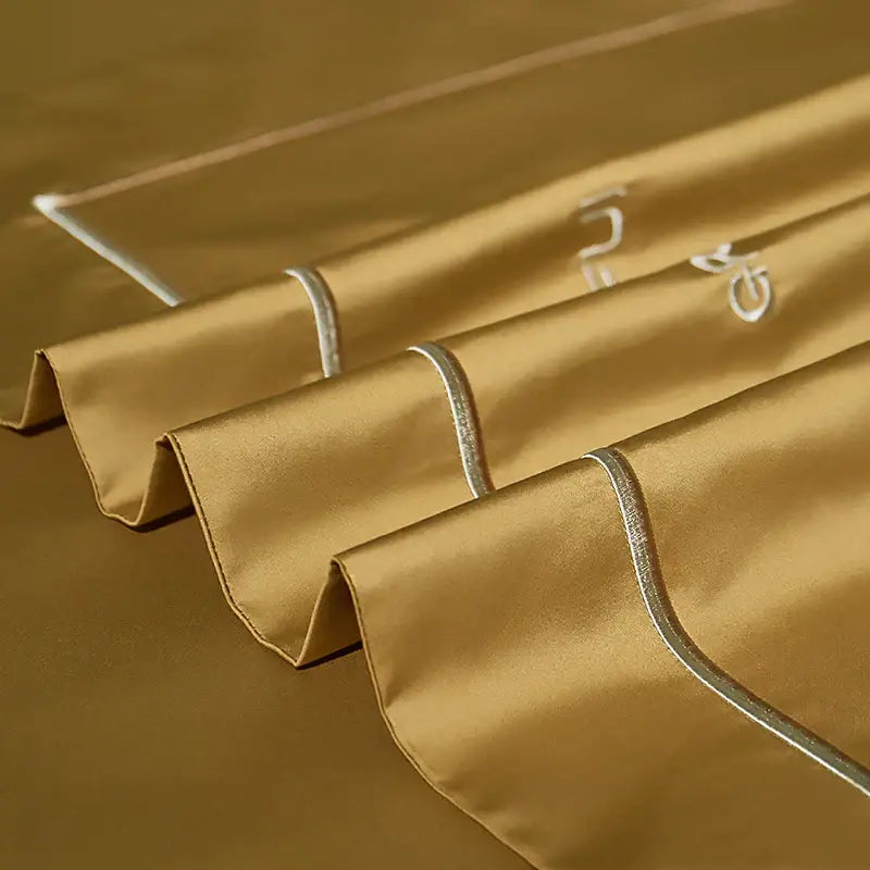 Golden satin egyptian cotton pillowcases with silver piping and white embroidered initials from decorbites 1000tc bedding set