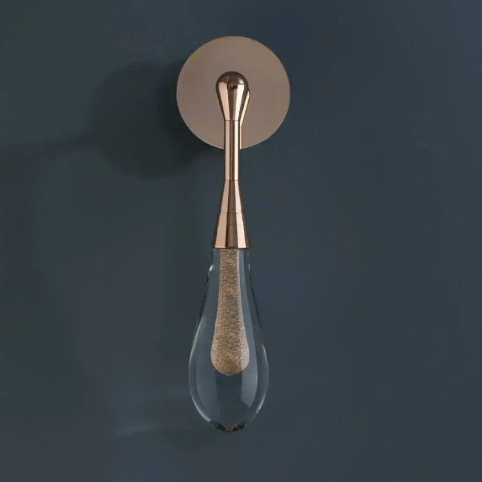 A sleek rose gold wall light with a teardrop glass shade and textured cork element from decorbites golden water droplets collection