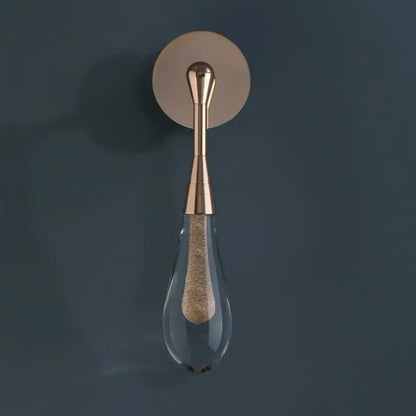 A sleek rose gold wall light with a teardrop glass shade and textured cork element from decorbites golden water droplets collection
