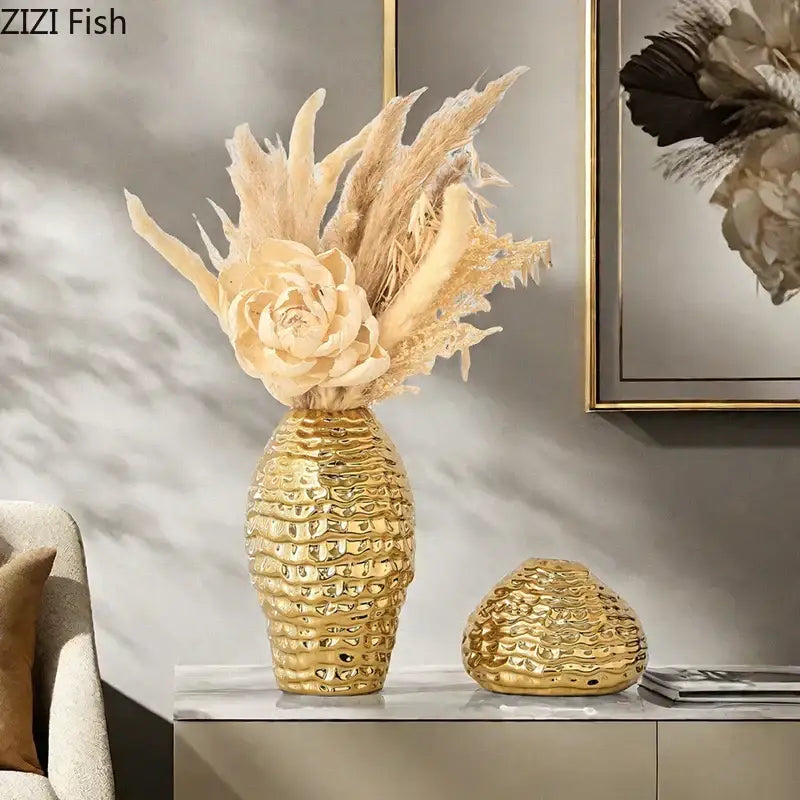 Golden wrinkle ceramic vase and matching spherical accent piece with textured gold decor holding dried pampas grass and cream flowers