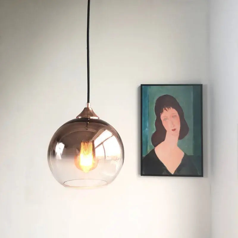 A sleek gradient glass ball chandelier with smoked glass and copper fixture for dining room lighting