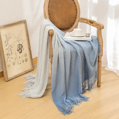 Soft gradient blue knit blanket with fringed edges draped on wooden chair decorbites gradient pineapple grid throw