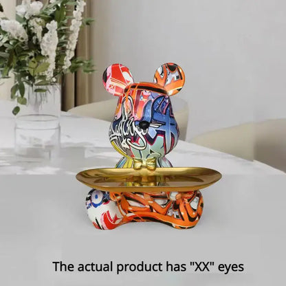 A vibrant graffiti bear figurine with glossy orange blue and red spray-paint patterns on a gold tray decorbites sculpture