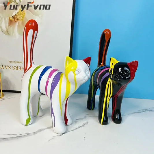 Two vibrant ceramic graffiti cat desk storage statues in black and white with colorful paint drip designs on marble surface