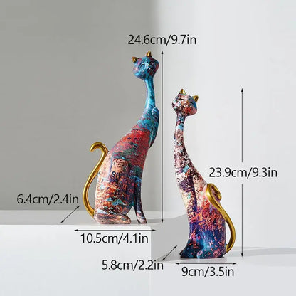 Two abstractly painted blue red and purple cat lovers resin figurines with gold-tipped ears and tails decorbites cat lovers