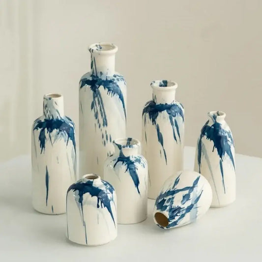 A collection of white ceramic vases with blue paint splatter decorbites graffiti ceramic vase for living room decor