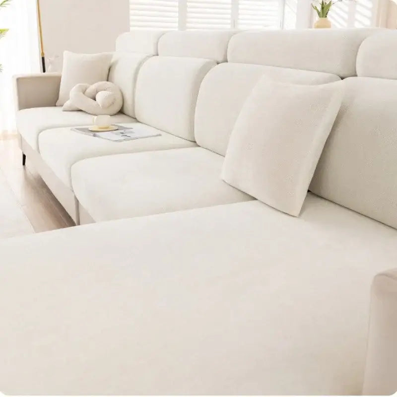 Cream-colored plush chenille sectional sofa with matching cushions featuring a gray and beige universal sofa cover